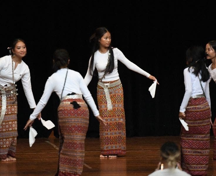 students in Myanmar traditional dress performing on stage
