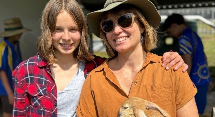 student with mother smiling and holding rabbit